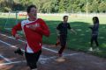 Frau Laue nimmt die Laufzeiten der Athleten für die 100m auf.